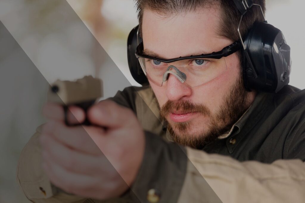 man holding a gun in an indoor shooting range